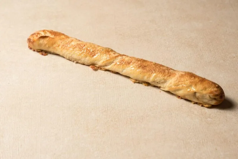 כיכר לחם כפרי עם קרום כהה על רקע בהיר.