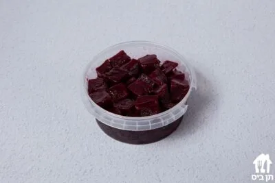 סלט סלק אדום בקוביות בקופסה שקופה על רקע לבן