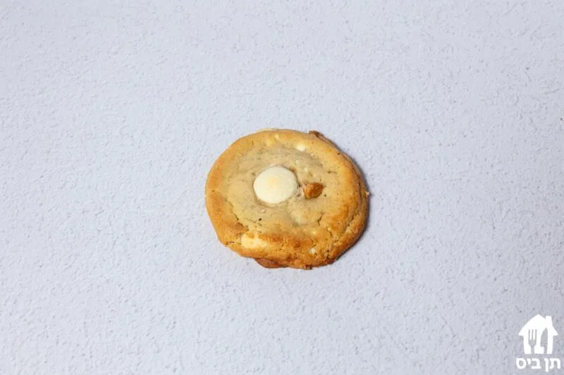 "עוגייה עגולה עם שקד במרכז על רקע לבן