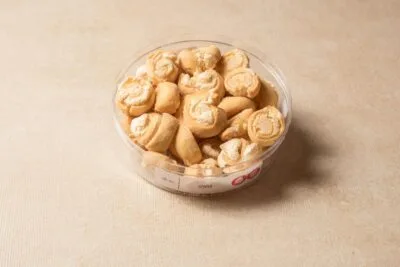 קערה עם עוגיות שושנים קטנות על רקע בהי